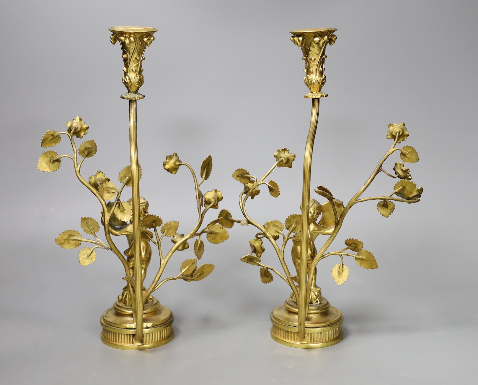 A pair of figural gilt metal candlesticks (Birmingham 1902 by Elkington & Company and Chester 1922(?) by Haseler Brothers, 28cm